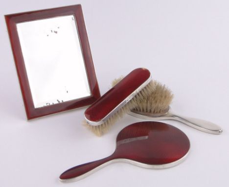 A silver and deep red enamel dressing table set, comprising a strut mirror 16.5cm x 13cm, a hand mirror length 20cm and 2 mat