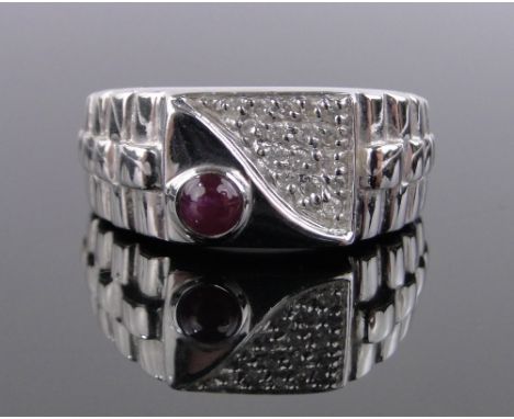 A 9ct white gold signet ring,set with cabochon ruby and diamonds, band width 10mm, size T.