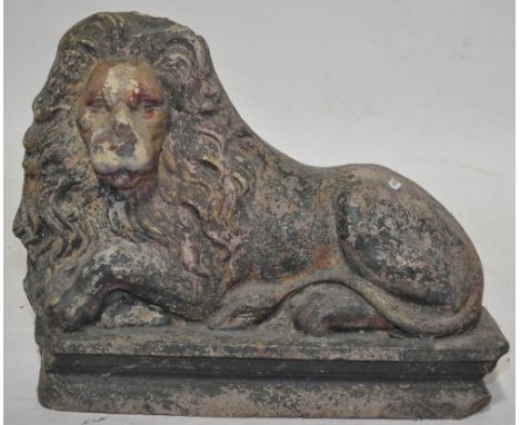 A painted Stoneware study of a recumbent lion, on plinth base, length 1'10", height 1'4".