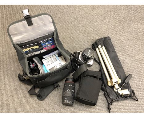 A Canon 350D digital camera in case with accessories together with a Sigma lens and a camera tripod 