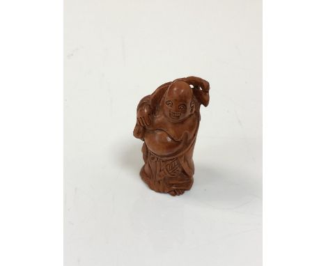 A carved Chinese hardwood netsuke - Gentleman holding a club