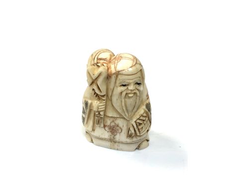 A carved Chinese bone netsuke - Elderly gentleman holding a sack on shoulder