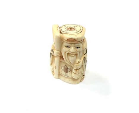 A carved Chinese bone netsuke - Gentleman holding staff and money bag