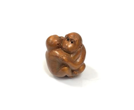 A carved Chinese hardwood netsuke -Two monkeys embracing