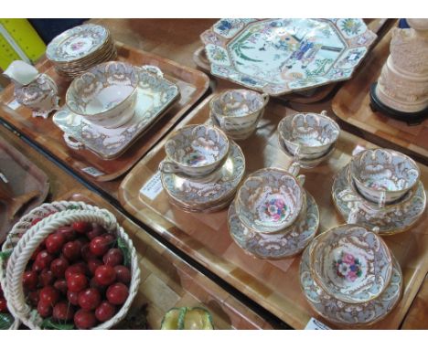 Two trays of 19th Century English porcelain teaware on a white ground with gilt and hand painted floral decoration comprising