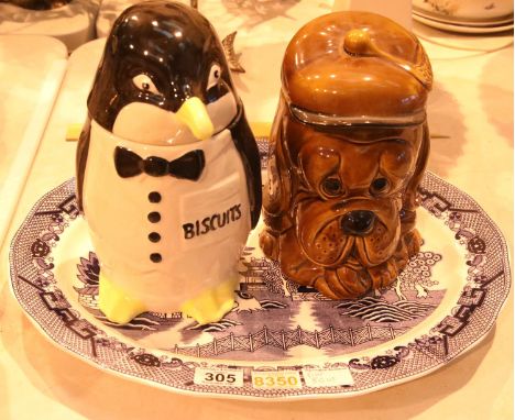 Two ceramic biscuit barrels depicting a dog and penguin and an Oriental blue and white ceramic charger. Not available for in-