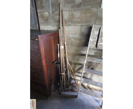 A quantity of long handled garden tools and a small metal plant stand