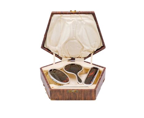 A cased child's silver and tortoiseshell dressing set by Adie Brothers Ltd. With two brushes, a mirror, and a comb, all with 