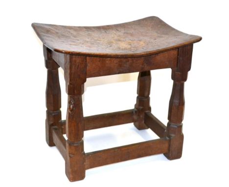 A Robert ''Mouseman'' Thompson Burr Oak Dish Top Stool, the adzed top on four octagonal legs joined by stretchers, with carve