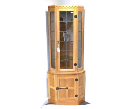 A Robert ''Mouseman'' Thompson Oak Corner Display Cabinet, penny moulded frieze, the upper section with leaded glazed door an