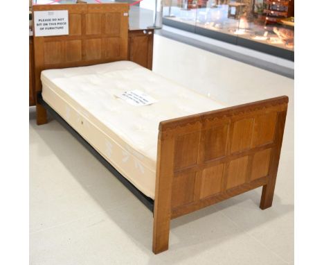 A Robert ''Mouseman'' Thompson Oak 3ft Single Panelled Bedstead, the panelled headboard and footboard with penny moulded top,