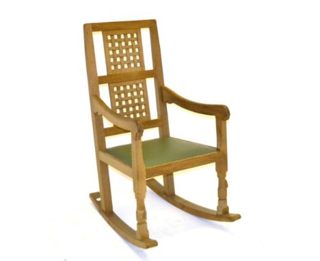 A Robert ''Mouseman'' Thompson Oak Rocking Chair, with two lattice back panels, shaped arms, green hide seats, medium fumed, 