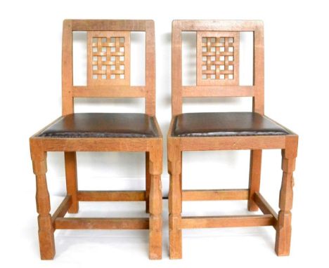 A Set of Four Robert ''Mouseman'' Thompson Oak Lattice Back Dining Chairs, with dark cow hide upholstered seats, on two octag