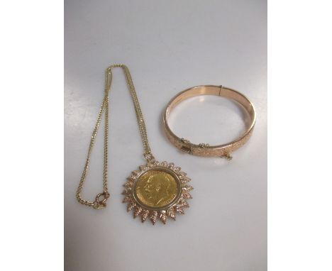 A 9ct gold engraved hollow snap bangle and a 9ct gold chain suspending a George V sovereign in a 9ct mount, gross weight 26g 