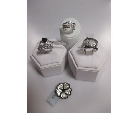 A silver cluster ring set with black and white diamonds, a set of three silver stacking rings set with white, black and champ