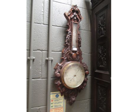 A late Victorian oak cased barometer carved with fruit and berries  