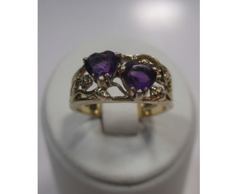 A 9ct gold lover's ring set with two heart shaped amethysts  