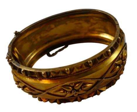 A Victorian gold hinged bangle, unmarked, circa 1880, the front with applied bead and wirework decoration, plain back, width 