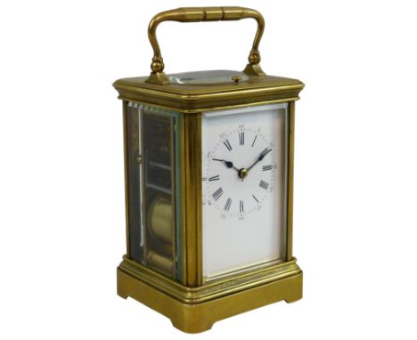 A late 19th/early 20th century brass repeating carriage clock, the white enamel dial with black Roman numerals, outer Arabic 