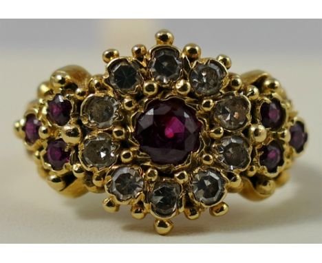 An 18ct gold Victorian style ruby and diamond cluster ring, the central mixed cut stone bordered by single cuts, ruby trefoil