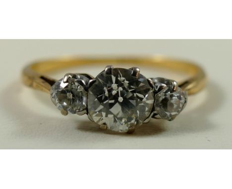 An 18ct gold and three stone diamond ring, claw set with an old brilliant cut stone weighing approximately 0.75cts, colour es