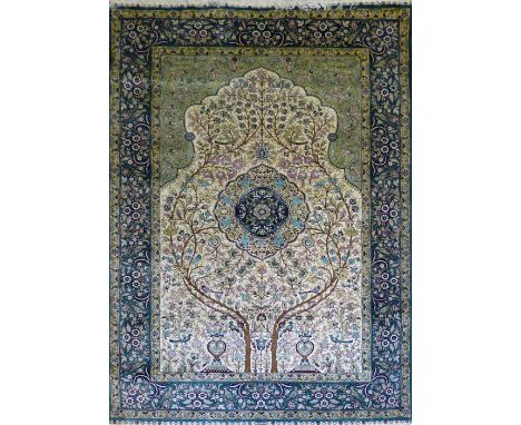 A Persian silk tree-of-life rug, the central oblong panel containing a split trunk tree enclosing a shaped circular medallion