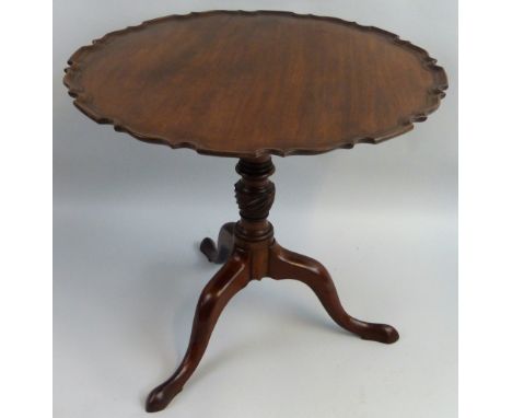 A George III style mahogany tilt-top tripod table, of circular form with pie-crust rim, on turned and wrythen fluted tapering