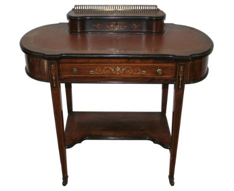 An Edwardian lady's rosewood writing table, with inlaid stringing, scrolls and urns, of rounded oblong form, the top with rai