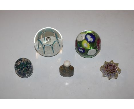 A Caithness "May Dance" paperweight; three other paperweights and a polished stone snuff bottle