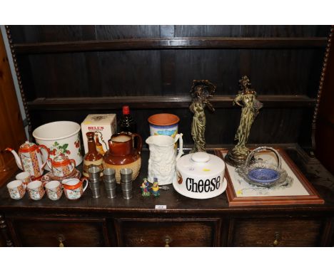 A pair of Art Deco style figures; an Atkinson &amp; Co 1903 Harvestware jug; a Bells Scotch whisky decanter and contents in o