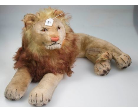 A mid 20th century Merrythought-type blonde plush lion, with cloth filled body and straw filled tail, stitched nose and claws