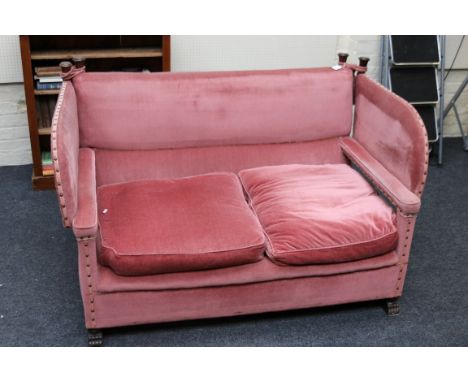 A 20th century two seat open arm Knole sofa, in raspberry fabric