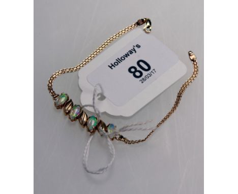 A four stone opal bracelet, the oval stones in claw mounts between textured oval spacers to a fancy link bracket, in fitted c
