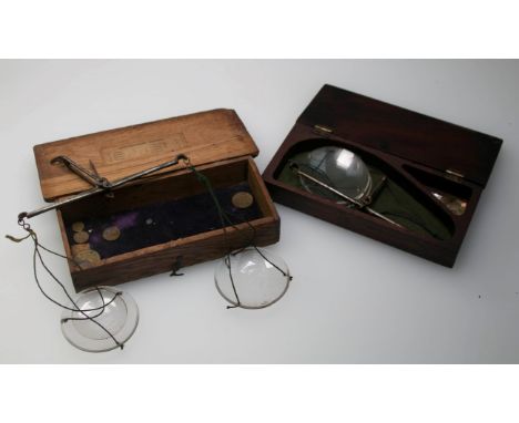 A set of  19th century oak cased apothecary's  balance scales, with iron beam and glass pans and weights, together with a set