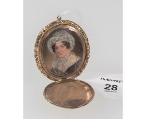 An early 19th century mourning locket, with hinged cover opening to reveal a head and shoulders portrait of a lady in lace bo