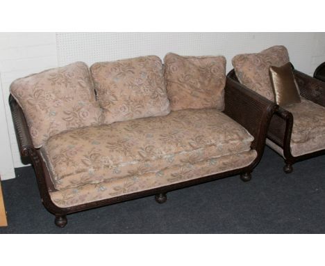 A carved mahogany double cane panel bergere lounge suite, with turned supports, the sofa 181cm wide