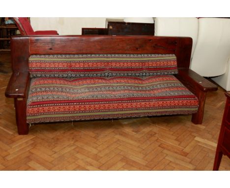 A Hill Gallery of London rustic hewn hardwood three seat sofa, with tribal kelim covering, bearing an engraved brass plaque w