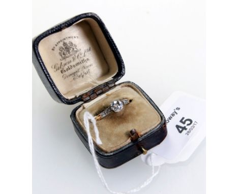 A single stone diamond ring, the cushion cut diamond in claw mount, with three stone diamond shoulders to a reeded shank