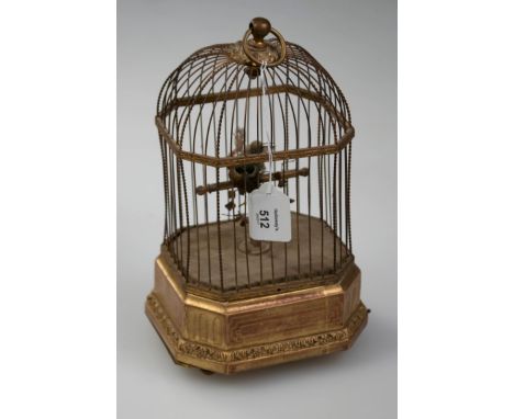 A c1900 probably Bontems of France singing bird clock automaton, the rectangular form domed gilt metal cage with plumed singi