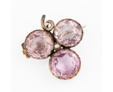 A amethyst brooch, set with three round cut amethysts in trefoil design, set in unmarked white metal.
