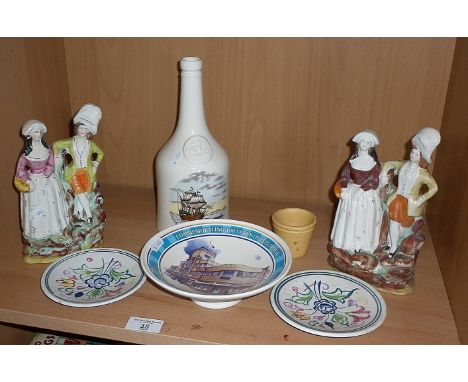 Two Staffordshire figure groups, three Poole Pottery dishes and a Copeland Spode wine bottle