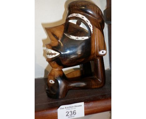 Modern Oceanic tribal art carved hardwood figure of two heads with mother of pearl inlaid eyes and teeth