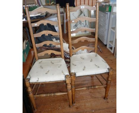 Pair of light oak ladderback dining chairs with seats upholstered in a rabbit printed fabric