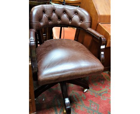 A SWIVEL OFFICE CHAIR upholstered and buttoned in brown leather and a standard lamp (2)