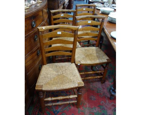 A SET OF FOUR ASH AND ELM LADDER BACK CHAIRS with rush seats