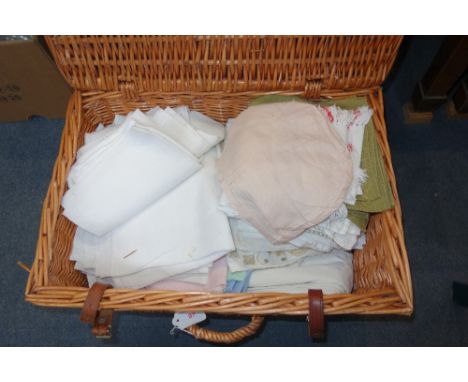 A VINTAGE WICKER HAMPER containing linen