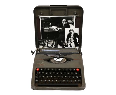 Eric Morecambe's cased typewriter, an Empire Aristocrat, together with two press photographs of him using it  ❧ This is from 