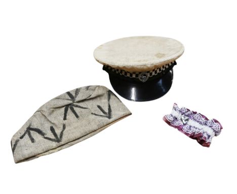Eric Morecambe's stage props, comprising a convict's cap, a police constable's hat, and a lace garter (3)  ❧ This is from Eri