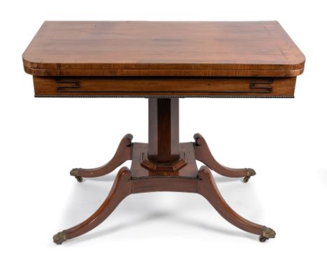 A Regency mahogany D shape card table, hinged cover with baize inset above frieze applied with ebony banding on central pilas