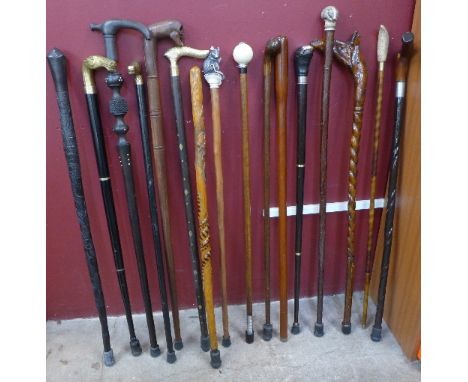 A collection of sixteen walking sticks and canes including one with flask, African carved stick, mouse and horse handled, etc